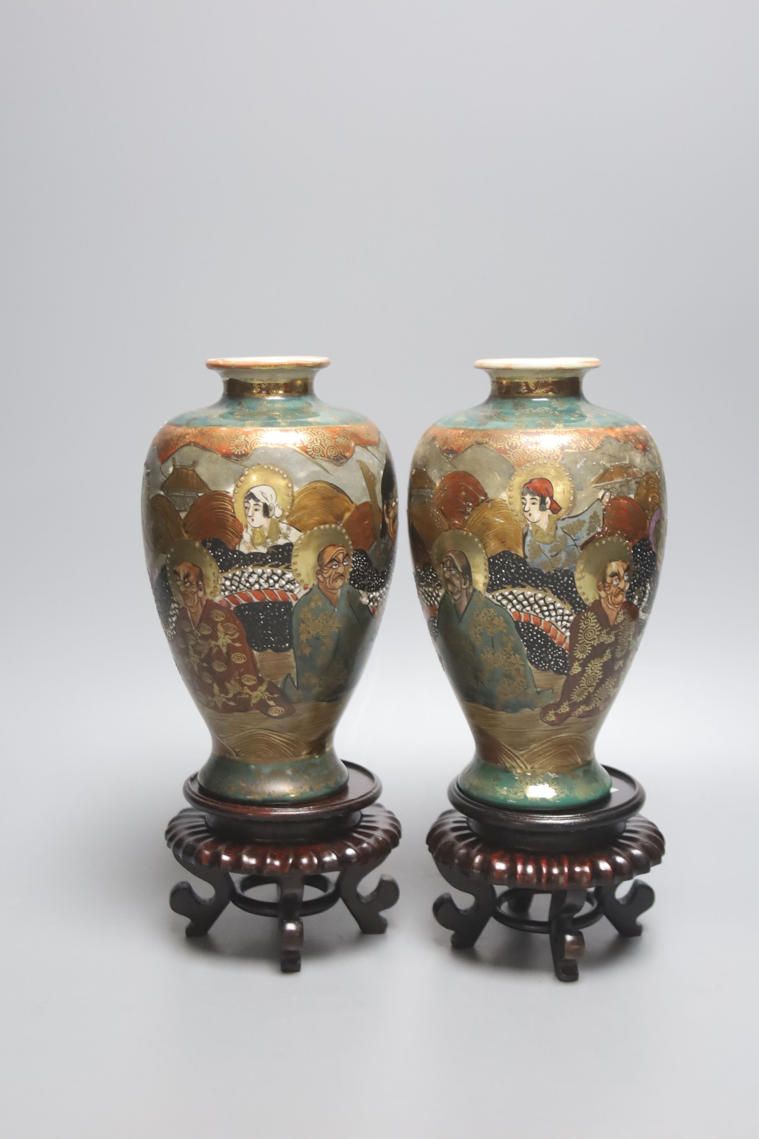 A pair of Japanese Satsuma pottery vases, depicting immortals, 17.5cm, wood stands